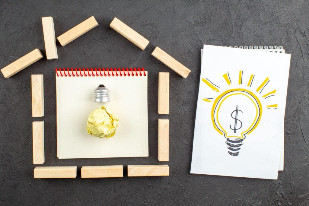 Energy savings concept with house model and light bulb