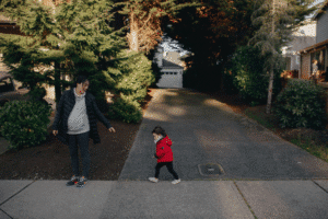 Parent and child standing in a residential driveway