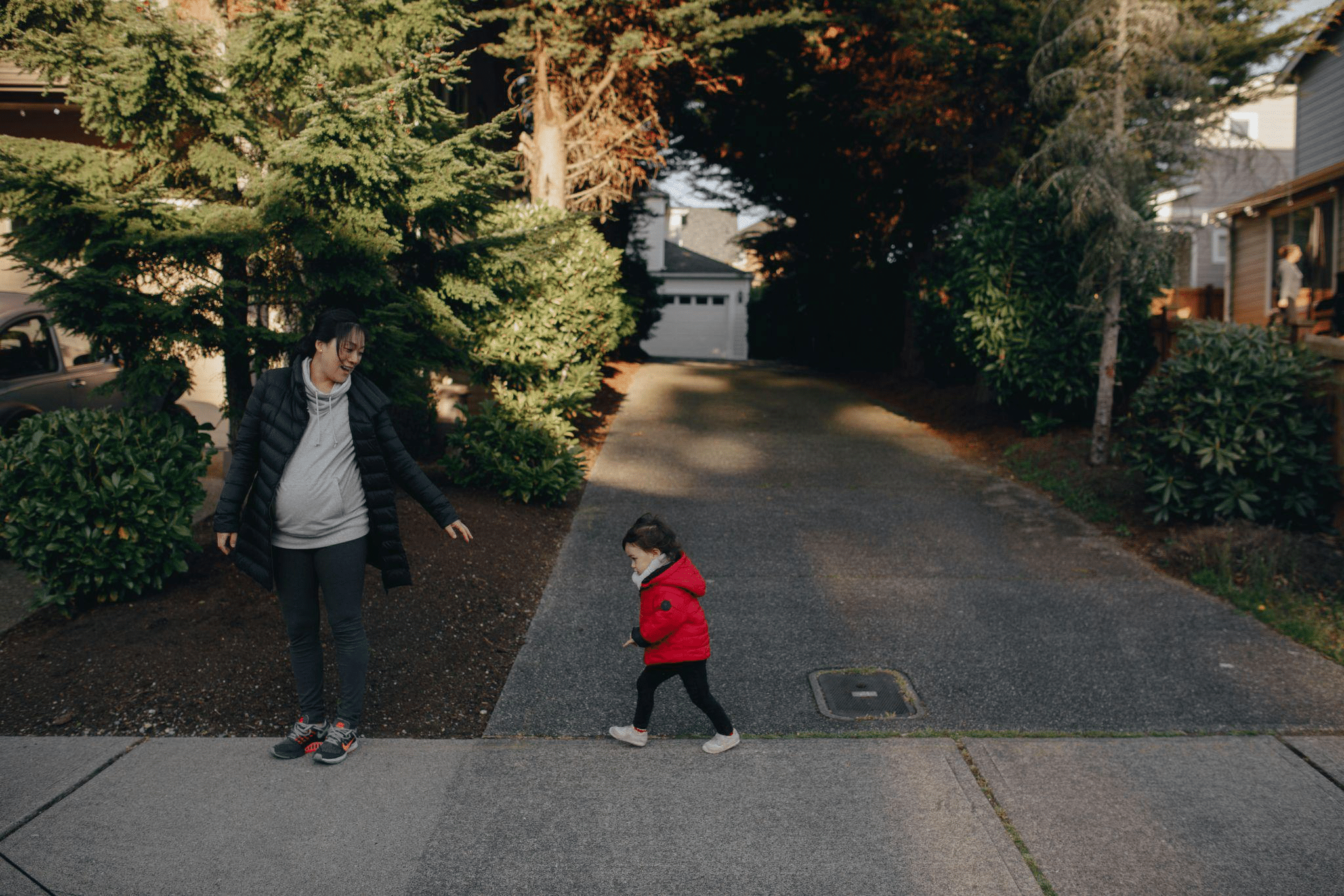 Parent and child standing in a residential driveway