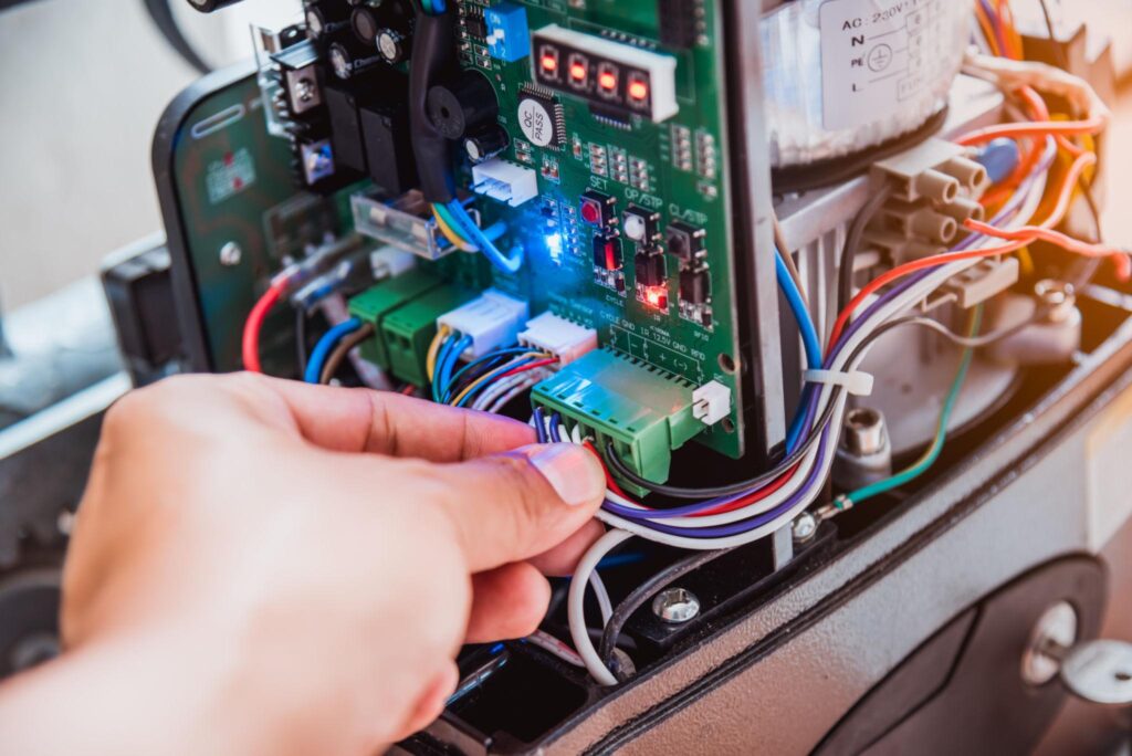 Technician testing automatic gate motor using emergency key for residential gate repair and security system in Vancouver